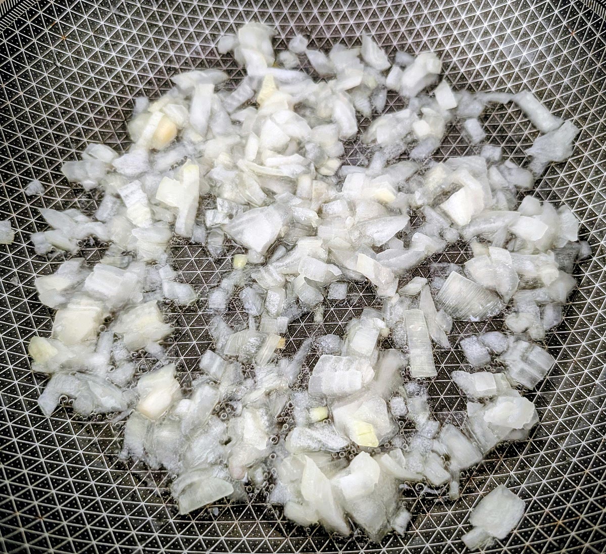 On a frying pan, heat the olive oil to medium, add the finely chopped 1/2 medium size white onion and reduce heat to medium-low. Add a pinch of salt to help them release the water and fry them until soft and translucent (about 5 minutes), stirring regularly to prevent them browning.