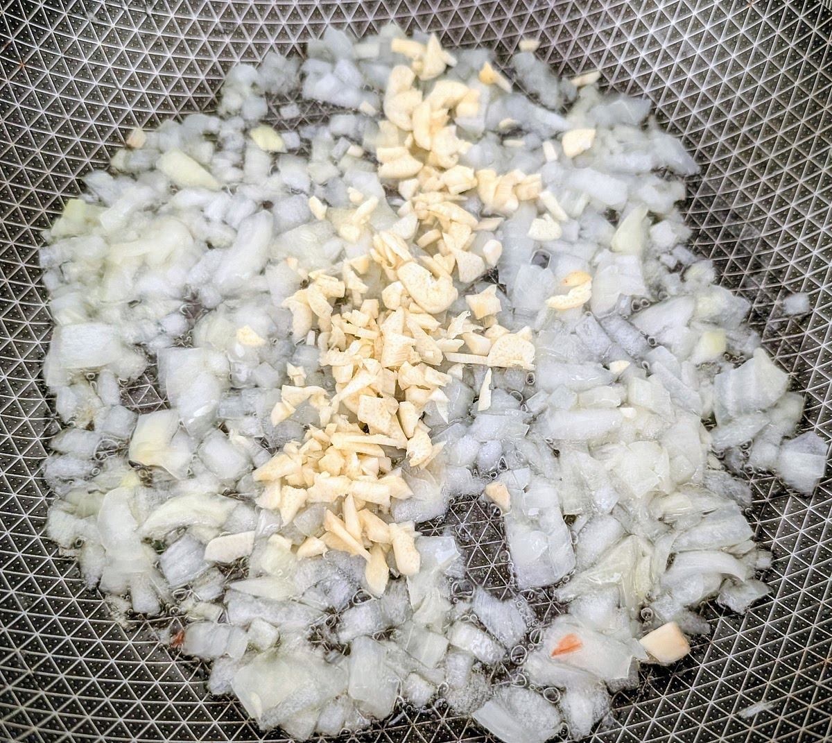 When the onions are soft and translucent, add the finely chopped garlic and fry for 1 minute.