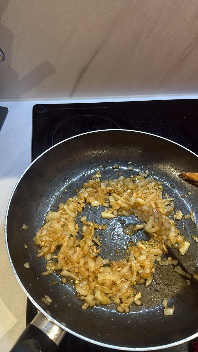 In the same pan, add the sliced onion and cook for 3–4 minutes until softened. Add the minced garlic and grated ginger, stirring for another minute until fragrant.