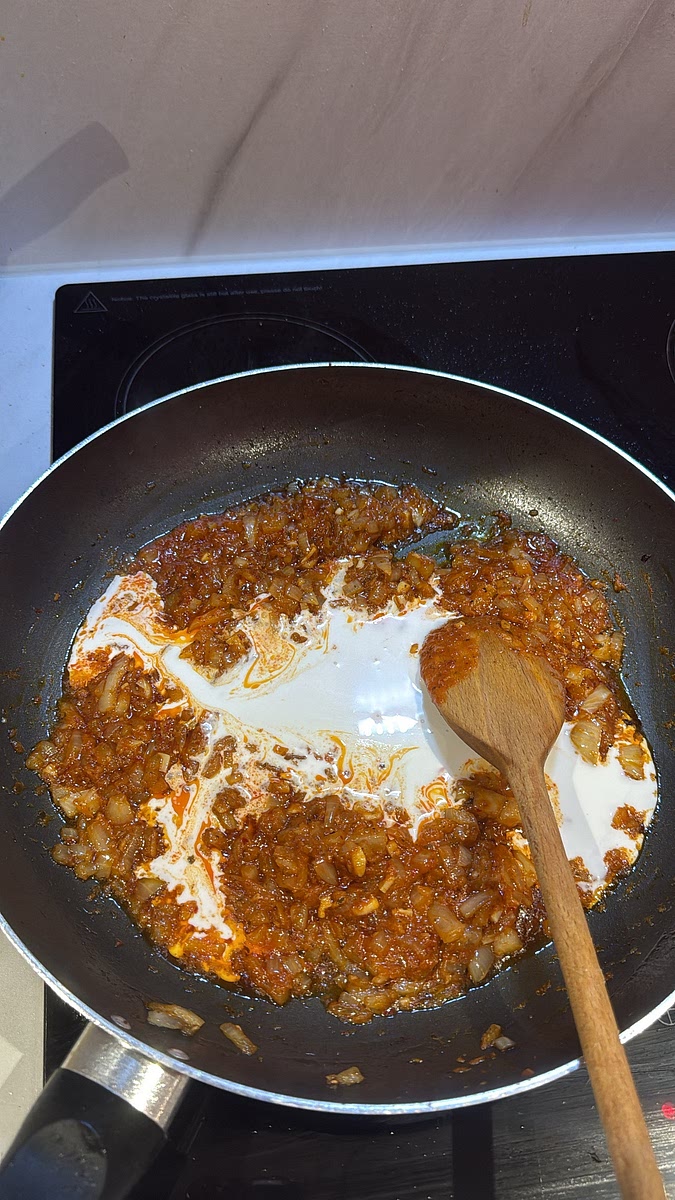 Gradually pour in the coconut milk, stirring until the curry paste is fully incorporated.