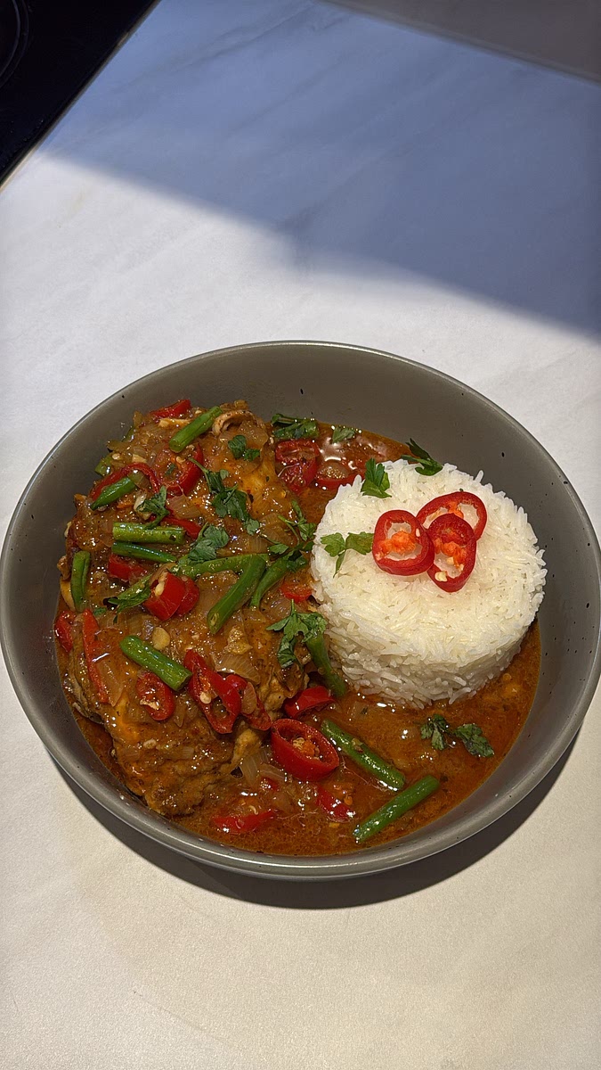 Spoon the Thai red coconut chicken curry over fluffy white rice, making sure to add plenty of sauce and green beans. Garnish with extra sliced red chilli if desired.