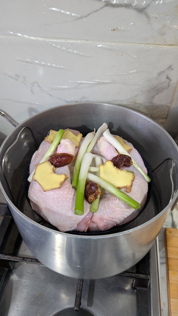 In a large flat bowl steam place a smaller bowl in the centre, face down. Lean 4 chicken bone-in thighs around it and place on a few slices of ginger, 2 stems chopped spring onion and a few jujube dates and steam for around 40 mins.