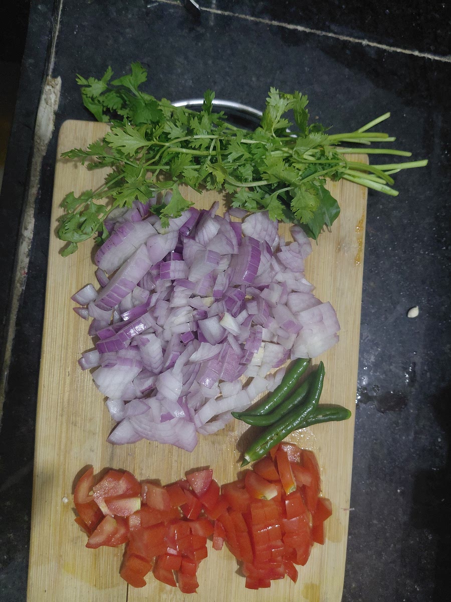 Dice 3 medium sized onions and big tomato, slit 4 green chillies, finely chop corriende leaves.