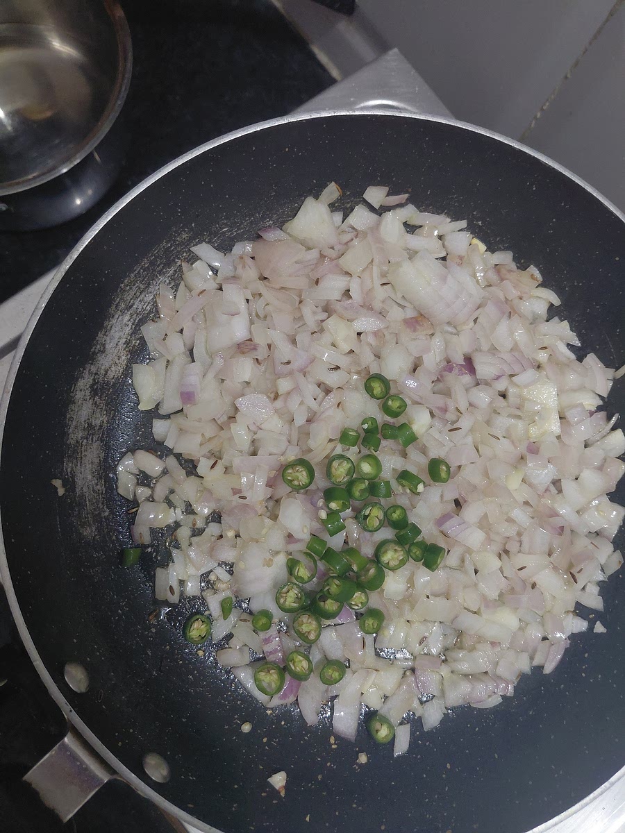 Add sliced green chillies after the onions soften a little.