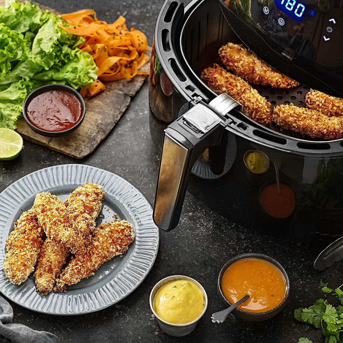Prepare the crispy chicken. Season chicken strips with garlic, paprika, salt and pepper. Coat in gluten-free flour, dip into beaten egg, then coat in gluten-free breadcrumbs. Lightly spray or brush with oil. Air-fry at 200°C for approximately 10–14 minutes, turning halfway, until golden and cooked through to 74°C internally.
