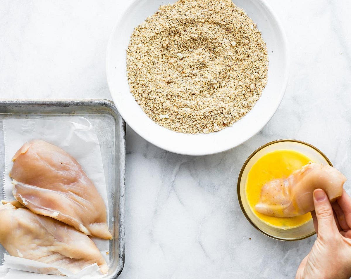 Coat the chicken. Pat the chicken dry. Whisk the egg in one bowl. Mix almond flour, tapioca flour, garlic powder, onion powder, paprika, salt and pepper in another. Following Dip each chicken strip into the flour mixture, then the egg, then back into the flour mixture. Press gently so the coating adheres.