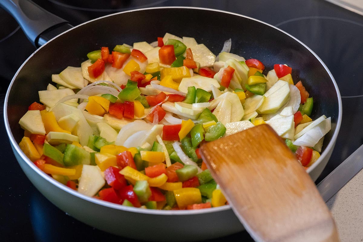 Add the vegetables. Add the onion, red pepper, yellow pepper and courgette to the same pan. Sauté for approximately 4–5 minutes until the onion begins to soften and the peppers develop a little colour. This adds sweetness and texture that complement the Cajun seasoning.