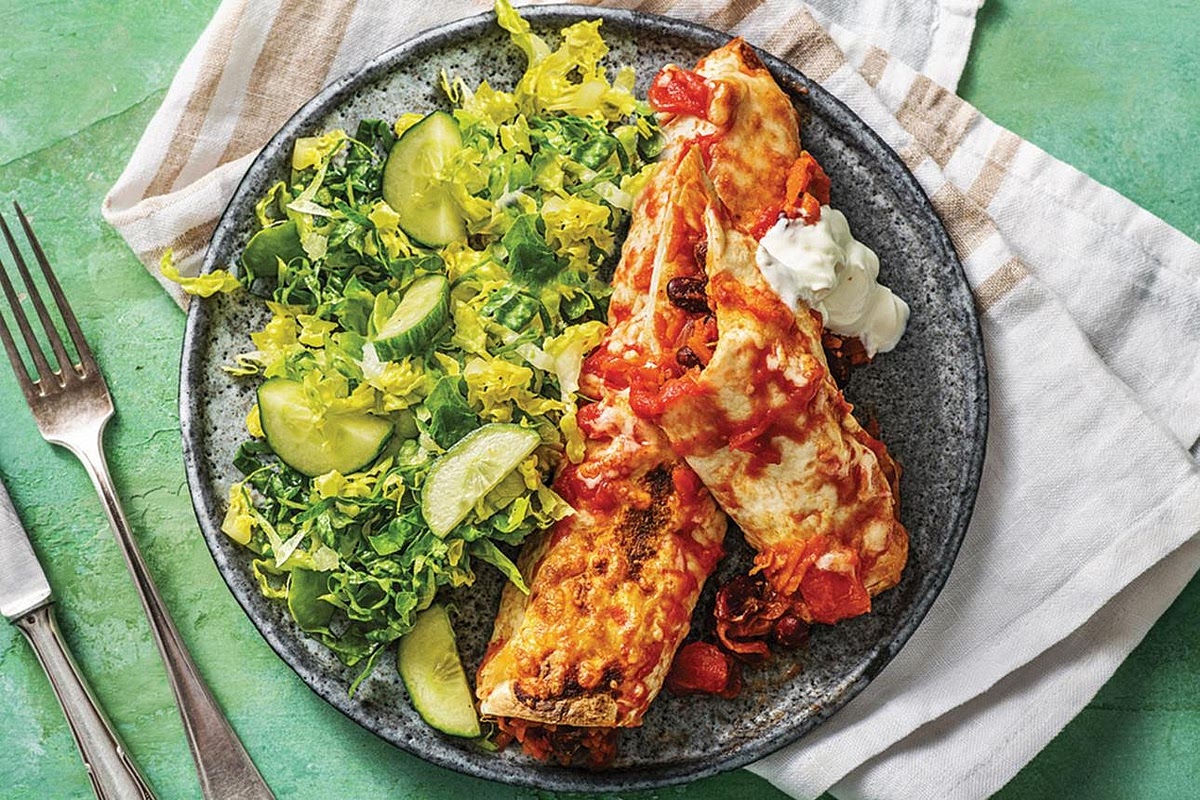 Serve your balanced dinner Serve two enchiladas per person with a generous helping of Mexican salad. Drizzle the enchiladas with avocado-lime crema and garnish with fresh coriander, chopped tomatoes or jalapeños if desired.