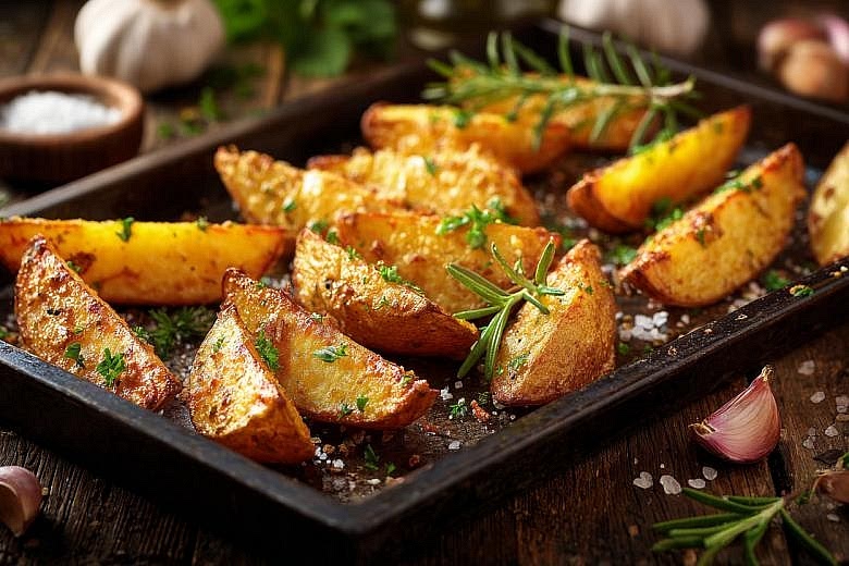 Start the garlic-rosemary potato wedges Preheat the oven to 200°C. Cut the baby potatoes into wedges, leaving the skins on. Toss with olive oil, garlic powder, rosemary, smoked paprika, salt and pepper. Spread in a single layer on a baking tray. Roast for approximately 35–40 minutes, turning halfway, until golden and tender. Begin roasting the potatoes around 15 minutes before adding the chicken nuggets to the oven.