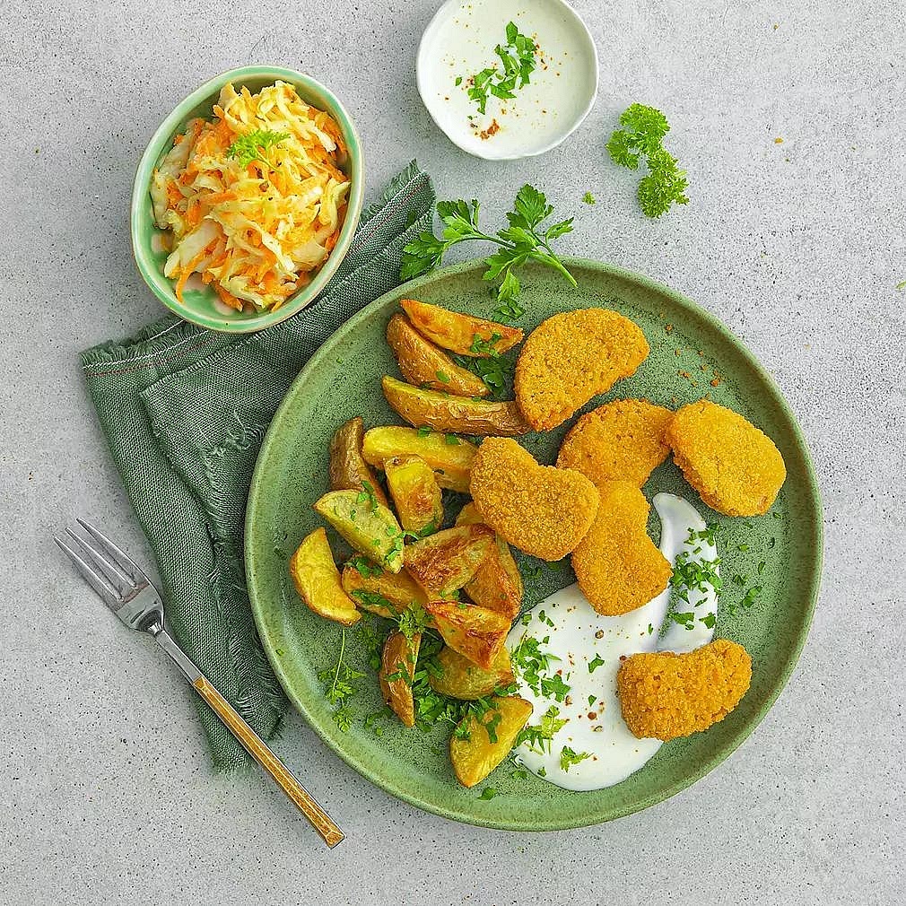 Assemble the dinner Divide the baked nuggets between two plates. Add a generous portion of rainbow chickpea slaw and the roasted potato wedges. Serve the honey-mustard sauce in a small bowl alongside the nuggets and potatoes.