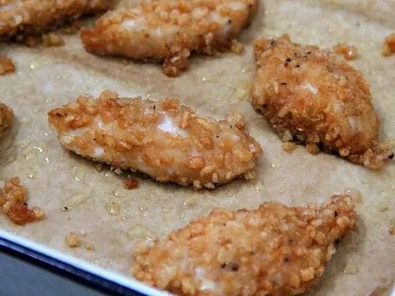 Coat the chicken tenders Pat the chicken dry with paper towels. Dip each tender into the flour, then the beaten egg, and finally the crispy cereal coating. Press gently to help the cereal adhere. Arrange the chicken in a single layer on a parchment-lined baking tray, ensuring the tenders don't touch.