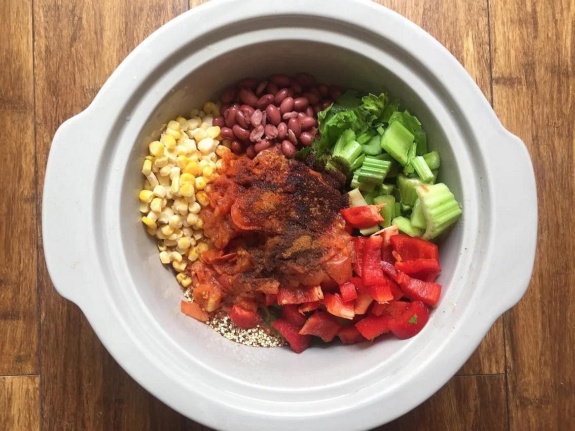 Assemble the slow cooker Add the chicken broth, quinoa, red enchilada sauce, green chillies, sweetcorn, black beans, onion, red pepper, cumin, chilli powder and garlic powder. Stir gently until evenly distributed. Place the thawed chicken breasts into the mixture and push them down so they are surrounded by liquid. Do not add extra water unless the mixture becomes unusually dry during cooking.