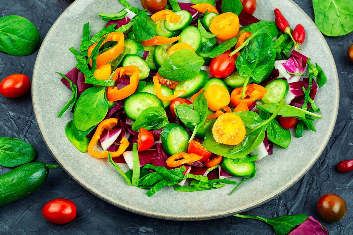 Prepare the Mediterranean rainbow salad Combine diced cucumber, halved cherry tomatoes, chopped pepper and baby spinach. Toss with the fresh lemon juice, dried oregano and optional olive oil. Season with black pepper and a pinch of salt. Keep the dressing light because the stuffed avocado already provides plenty of creaminess.