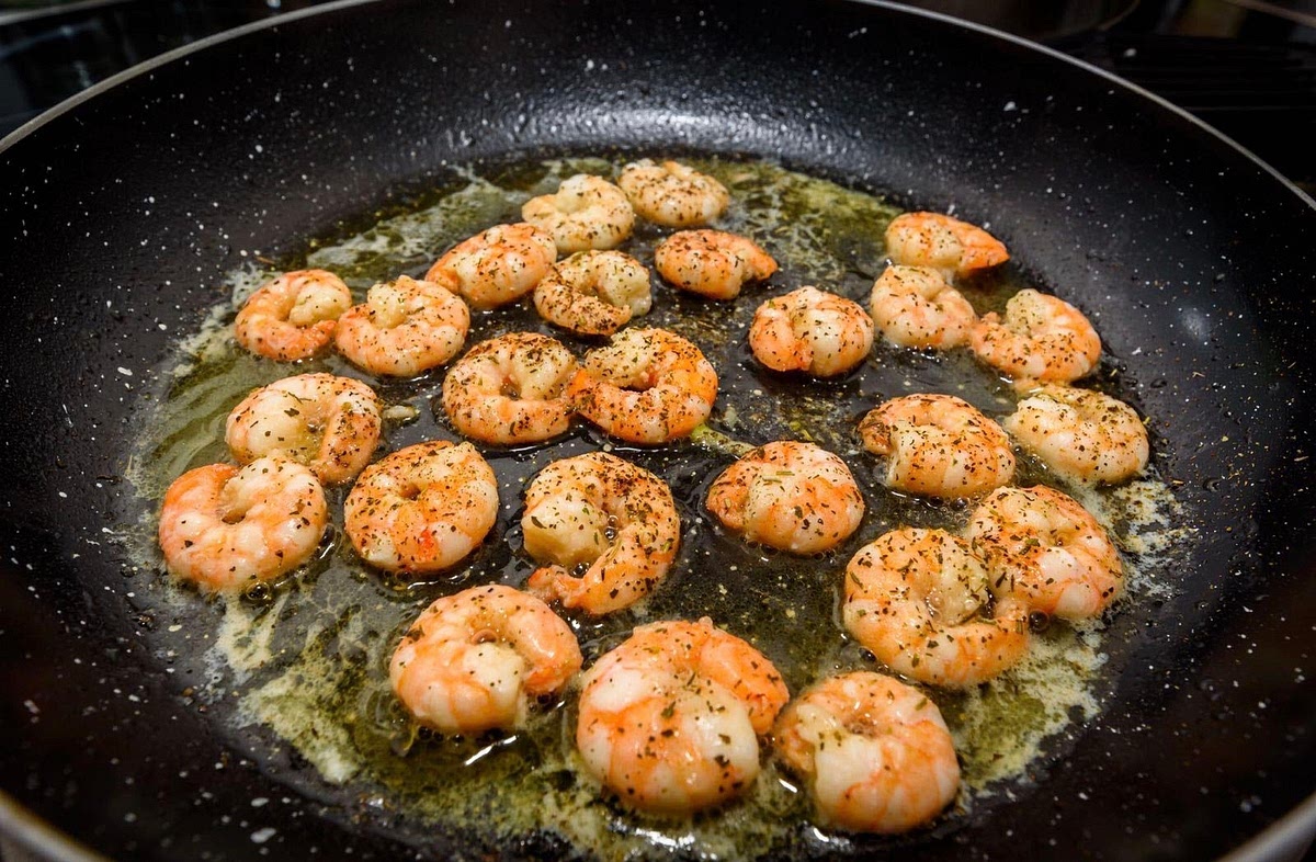 Pat the shrimp dry with kitchen paper. Heat the olive oil in a large frying pan over medium-high heat.
Season the shrimp with salt and black pepper. Cook for approximately 1-2 minutes per side, until pink and opaque. If using pre-cooked shrimp, warm them briefly instead. Transfer to a plate.