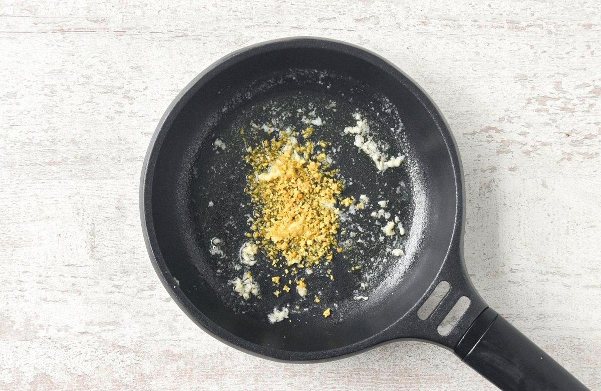 Reduce the heat to medium-low. Add the butter to the same pan.
Once melted, add the finely chopped garlic and cook for 30-45 seconds, without letting it brown.
Add the finely grated zest of approximately half the lemon and 2 tablespoons of lemon juice. Pour in 100 ml of reserved pasta water and stir well.