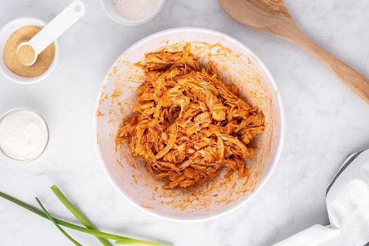 Prepare the buffalo chicken mixture In a mixing bowl, combine the mayonnaise, dairy-free cream cheese or cashew cream, buffalo sauce, garlic powder, dill, chives, paprika and lemon juice. Stir until smooth. Fold in the cooked shredded chicken, making sure it is evenly coated. Taste and add more hot sauce if desired. Use a clean spoon for tasting.