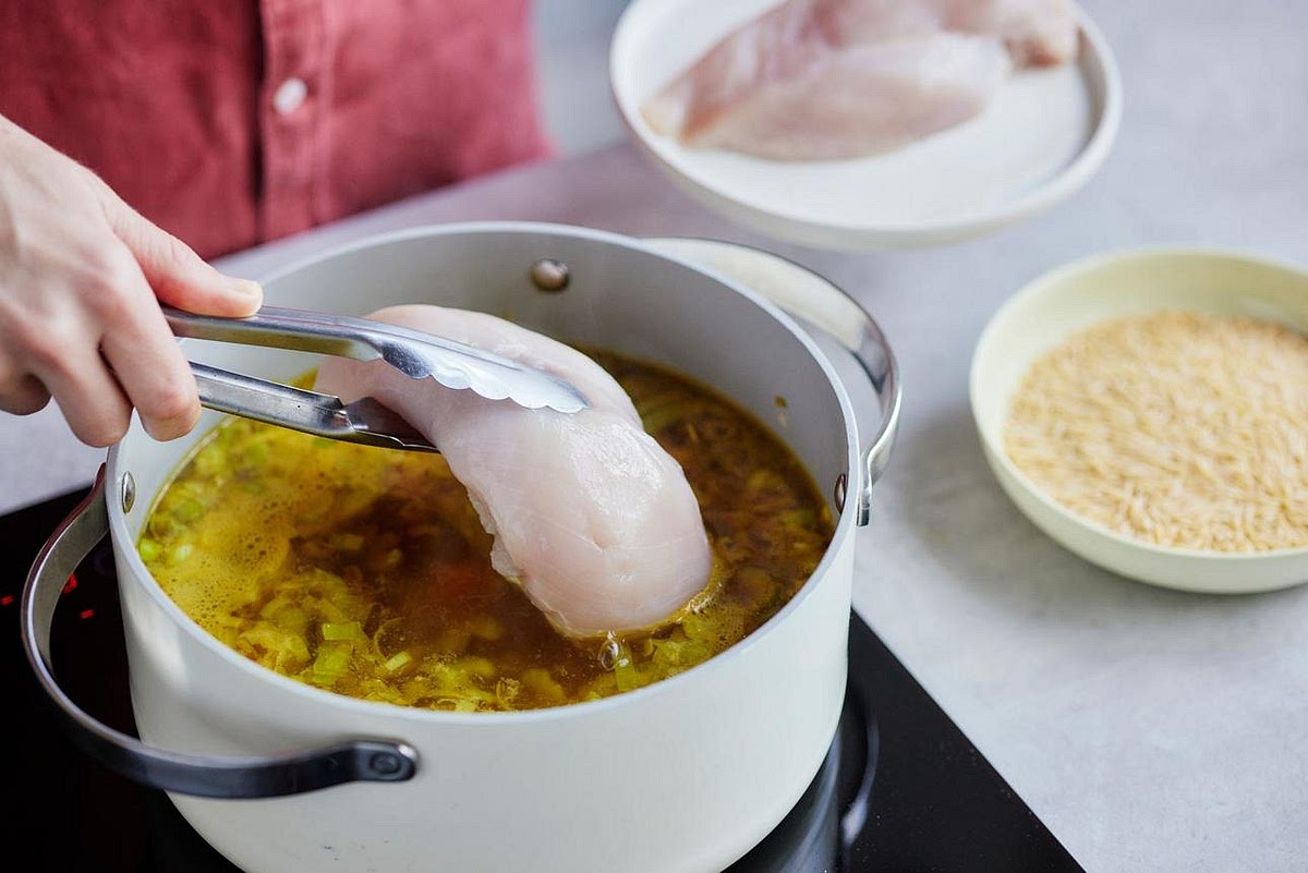 Simmer the chicken Pour in the chicken or bone broth and stir thoroughly. Add the chicken breasts and bring the soup to a gentle boil. Reduce the heat, partially cover and simmer for approximately 20–25 minutes, depending on the chicken's thickness. During the final 10 minutes, add the diced courgette. The chicken must reach an internal temperature of 74°C before shredding.