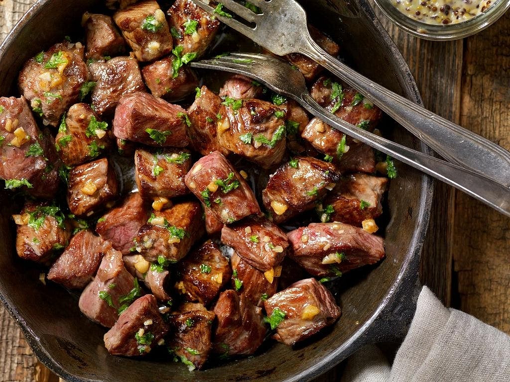 Sear the steak Heat the remaining teaspoon of olive oil over medium-high to high heat. Add the steak bites in a single layer and sear for approximately 1–2 minutes per side, turning to brown the exposed surfaces. Cooking time depends on the size of the cubes and your preferred doneness. A food-safety recommendation for beef steak is 63°C internally, followed by a 3-minute rest. Transfer to a warm plate while preparing the garlic-herb butter.