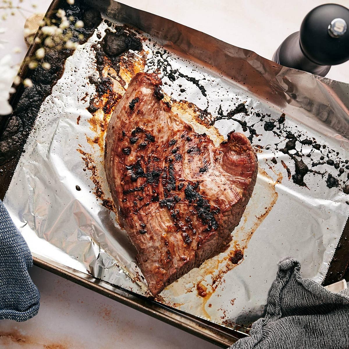 Grill the steak Switch the oven to its grill/broil setting. Place the steak on the grill-safe baking tray and position it approximately 10–15 cm beneath the heating element, following your oven's guidance. Grill for approximately 5–7 minutes on the first side, turn, and cook for another 4–7 minutes depending on thickness. For a conservative food-safety recommendation, cook whole beef steak to 63°C internally, followed by a 3-minute rest. A thinner flank steak may reach temperature sooner, so use a thermometer instead of relying on time alone. Let the steak rest for approximately 5 minutes before slicing.
