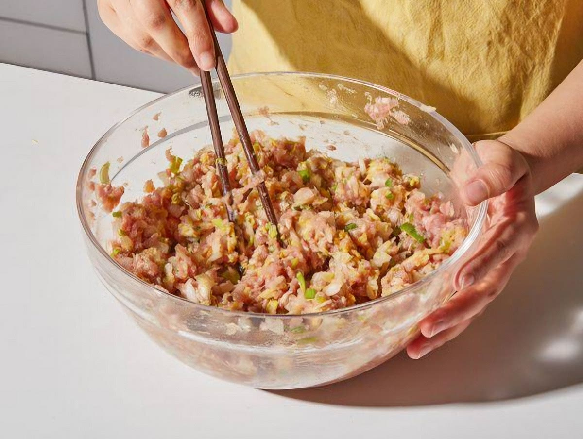Prepare the filling
Preheat oven to 375°F (190°C). In a large bowl, mix the ground pork, chopped cabbage, green onions, ginger, garlic, sesame oil, 2 tablespoons of soy sauce, and black pepper.
