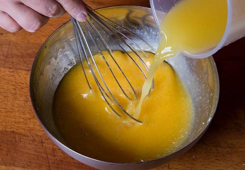 In a large bowl, whisk the eggs and sugar together for 1-2 minutes. Add the melted butter, allowing it to cool slightly first, followed by the orange juice, milk, vanilla extract and orange zest. Mix until combined.
