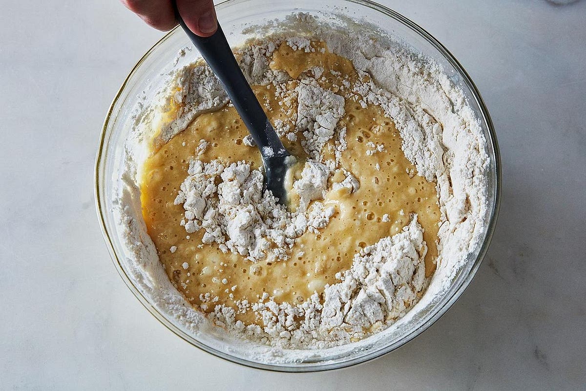 In a separate bowl, combine the flour, baking powder and salt. Add the dry ingredients to the wet mixture and gently fold with a spatula until just combined. A few small lumps are fine. Avoid overmixing, as this can make the muffins dense.