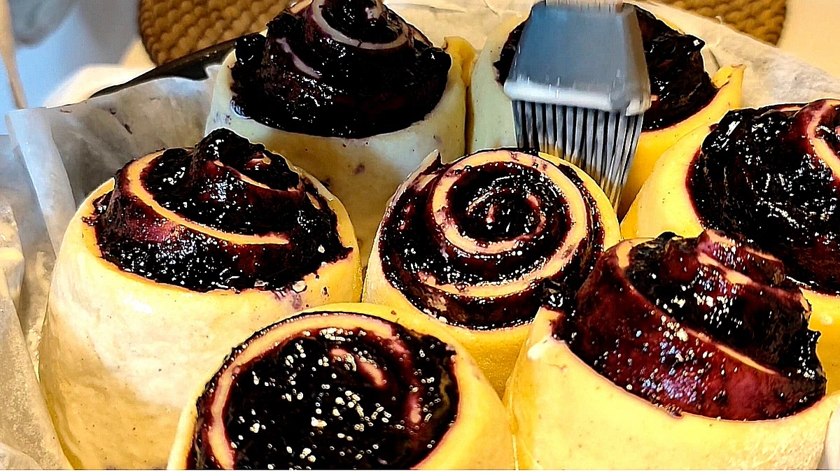 Brush the risen rolls with heavy cream, mixed with a drizzle of honey.